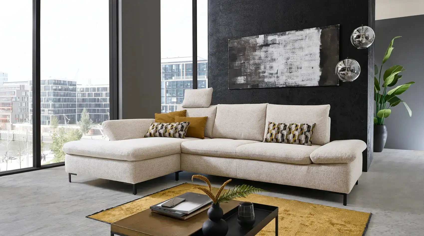 Cremefarbenes Ecksofa mit Stoffbezug in einem Wohnzimmer, davor ein Couchtisch und ein Teppich